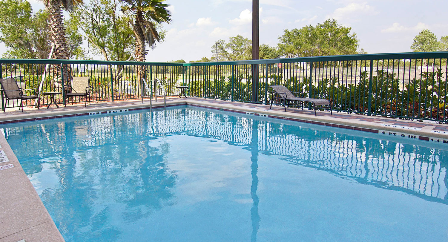 dip into a large outdoor pool with a beautiful view of the green hotel grounds