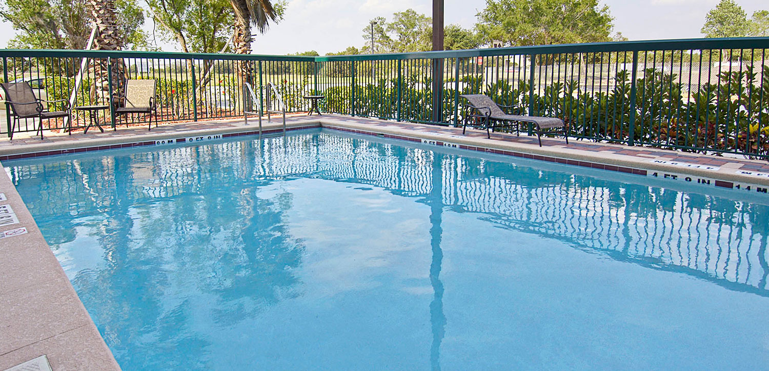 outdoor swimming pool filled with fresh blue water with lounge chairs