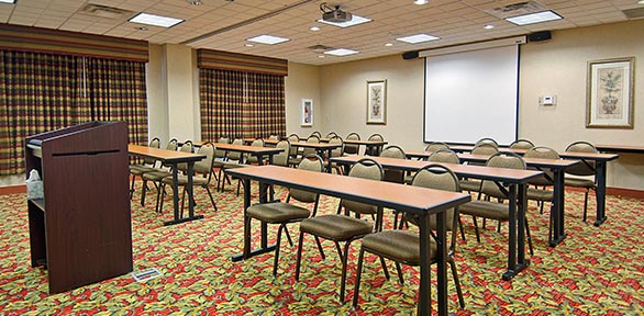brown podium looking over classroom style layout in a meeting room