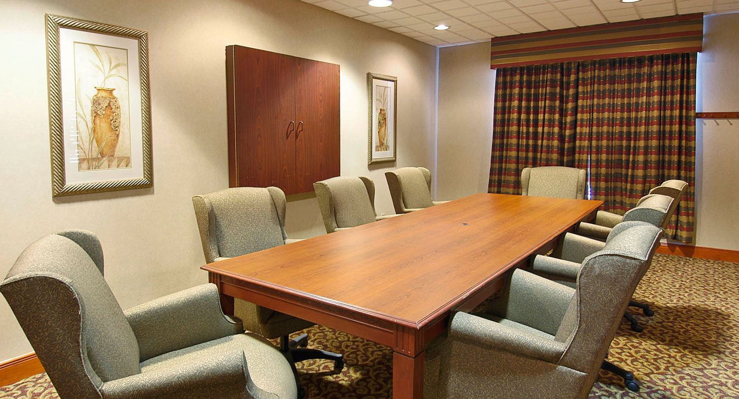 brown wood tv casing with a boardroom style layout in a meeting room